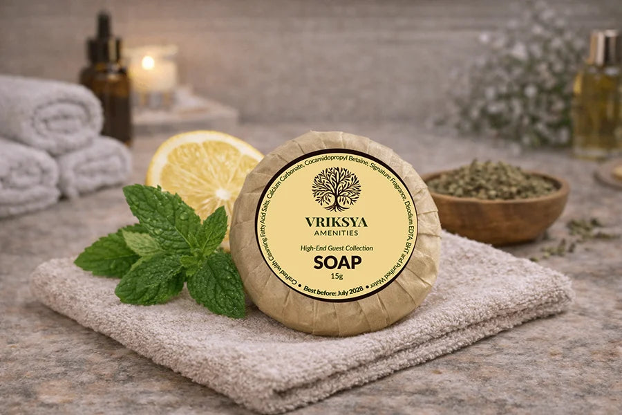 Vriksya Amenities soap bar on a towel with lemon, mint, and other items in the background