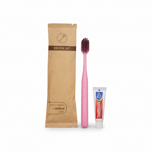 Dental kit with toothbrush, toothpaste, and packaging on a towel in a bathroom setting.