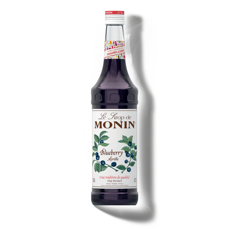 Bottle of Monin blueberry syrup on a white background