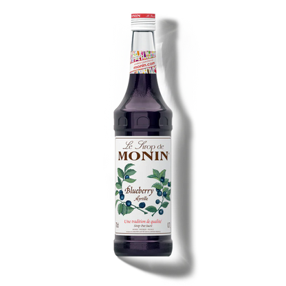 Bottle of Monin blueberry syrup on a white background