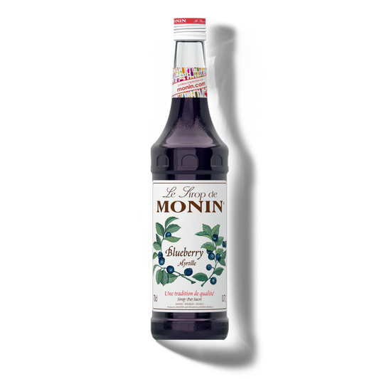 Bottle of Monin blueberry syrup on a white background
