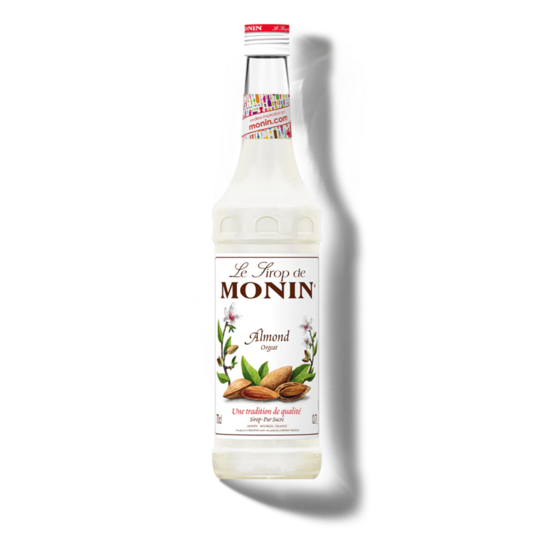 Monin almond syrup bottle on a white background