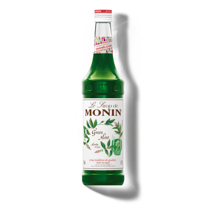 Green bottle of Monin syrup with a white label on a white background