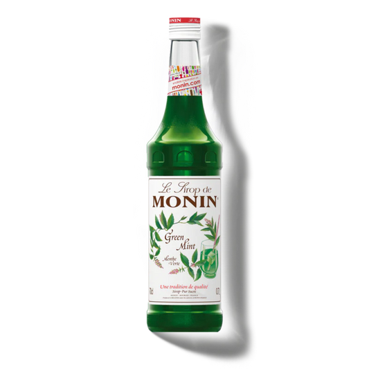 Green bottle of Monin syrup with a white label on a white background
