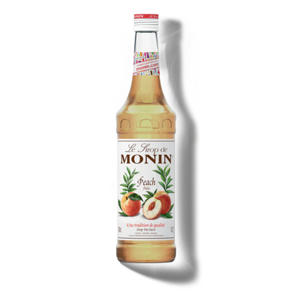 Monin peach syrup bottle on a white background