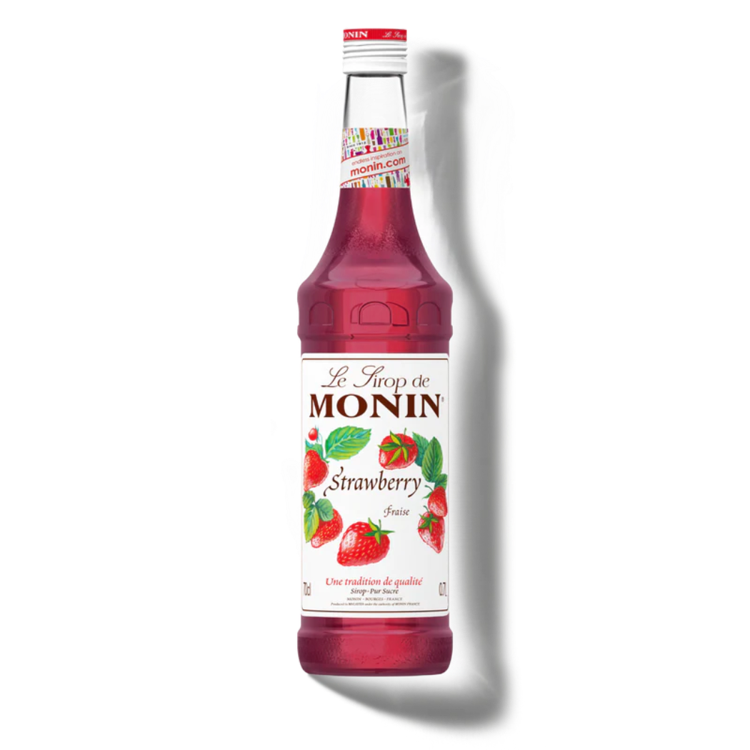 Bottle of Monin strawberry syrup on a white background
