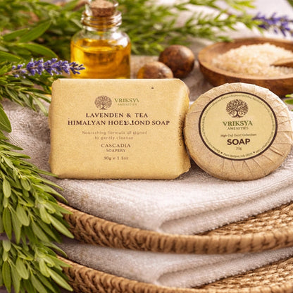 Two soap bars with 'Vriksha' branding on a woven mat with lavender and tea leaves.